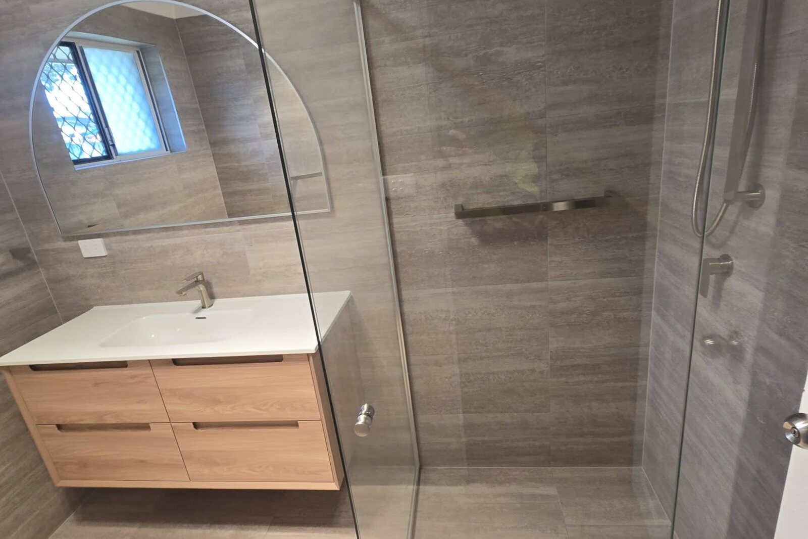 Completed bathroom renovation by SLJ Express Tiling with 300x600 wall and floor tiles and a new semi-frameless shower screen