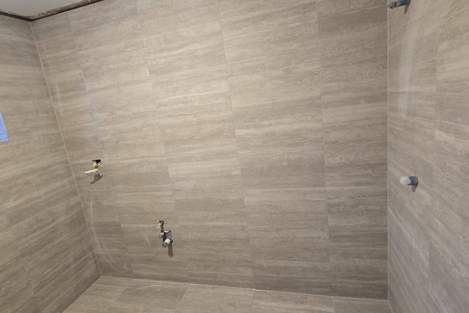 300x600 bathroom wall tiles laid to the ceiling in a straight pattern with 1.5mm joints by SLJ Express Tiling