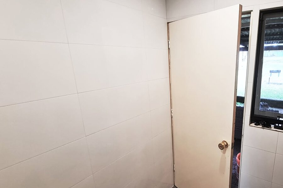 Laundry walls tiled in 300x600 white gloss tiles with matching white matte grout
