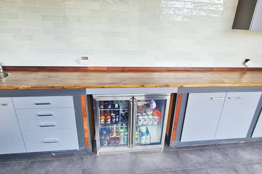 76x302 subway tiles laid in a brick pattern as an outdoor kitchen splashback, with white grout and sealed joints
